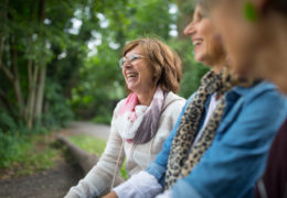 Bien avec les autres, retraitée qui rigole avec d'autres personnes dans un parc