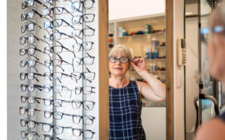 Bien être, bien vieillir, retraitée qui est chez un opticien entrain d'essayer des lunettes.