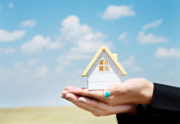 Bien dans mon environnement, mains de femme tenant une maison miniature