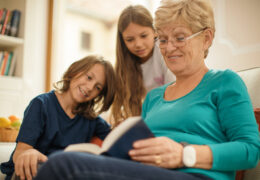 Bien avec les autres, une femme retraitée fait la lecture avec ses deux petits-enfants