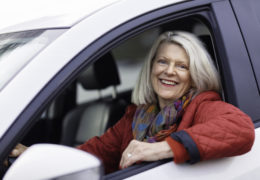 Bien dans mon environnement, une femme accoudée à la fenêtre de sa voiture en souriant