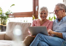 Bien avec mes droits et le numérique, couple de retraité dans un canapé qui utilise un ordinateur portable