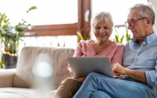 Bien avec mes droits et le numérique, couple de retraité dans un canapé qui utilise un ordinateur portable