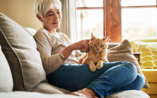 Bien dans mon environnement, femme câlinant son chat dans sa maison