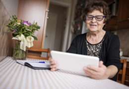 Bien avec mes droits et le numérique, retraitée assise à une table qui utilise une tablette