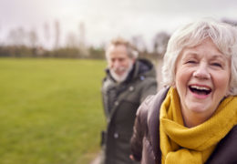 Bien être, bien vieillir, couple de retraités qui fait une balade en extérieure et qui rigolent.