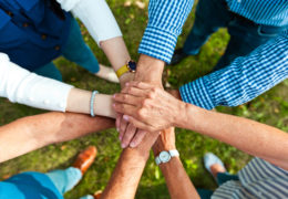 Bien être, bien vieillir groupe de personne aillant posé leurs mains les une sur les autres.