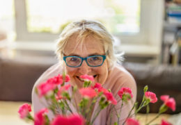 Bien dans mon environnement, une femme souriant derrière un bouquet de fleur