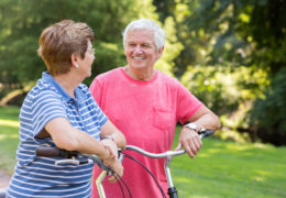 Bien dans mon environnement, un couple se souriant dans un parc avec des vélos en mains