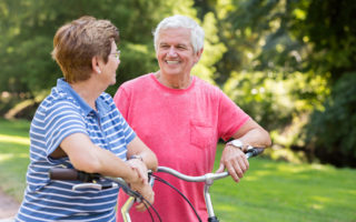 Bien dans mon environnement, un couple se souriant dans un parc avec des vélos en mains