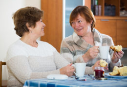 Bien démarrer ma retraite, deux retraitées mangent de la brioche en buvant un café et en rigolant