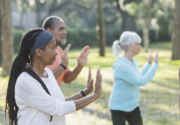 bien être, bien vieillir, groupe de retraités dans un parc pratiquant la meditation.