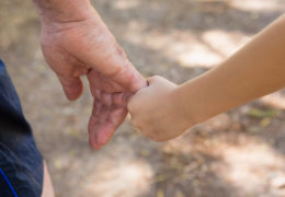 Bien avec les autres, main d'enfant qui tien la main d'un retraité