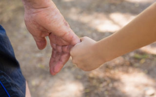 Bien avec les autres, main d'enfant qui tien la main d'un retraité