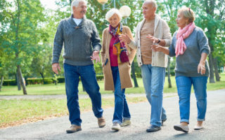 Bien avec les autres, groupe de retraité qui marchent dans un parc et discutent